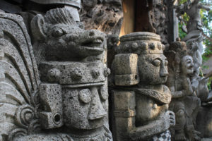 The sun reflects on traditional Balinese stone carvings.